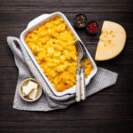 Baked macaroni and cheese in a baking dish, golden and crispy on top with cheese oozing out