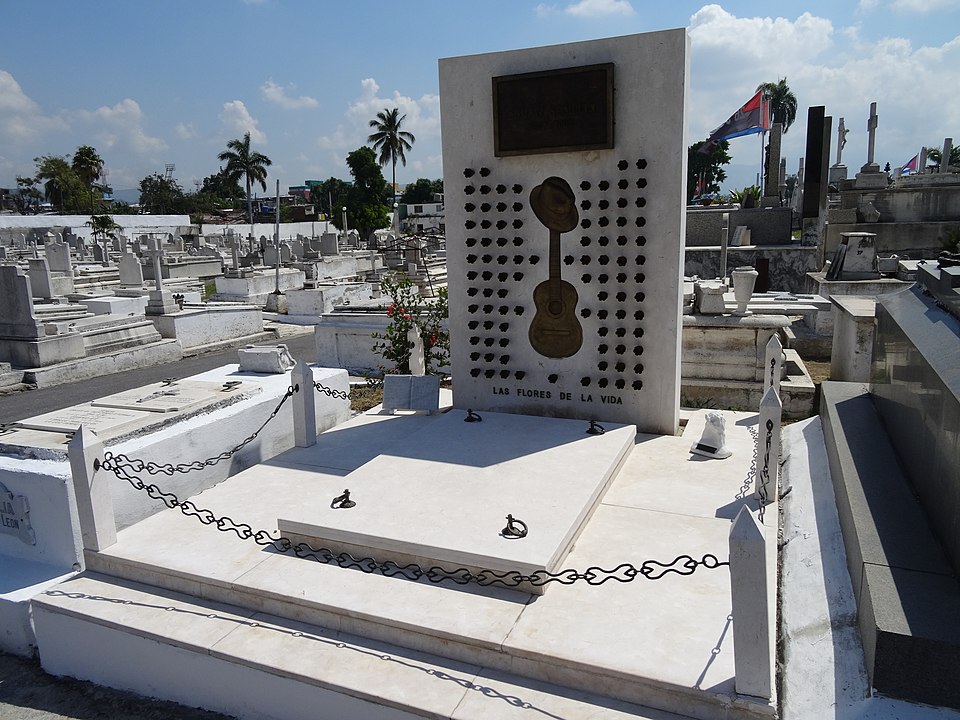 The resting place of Compay Segundo, marked with a solemn tombstone and surrounded by flowers.
